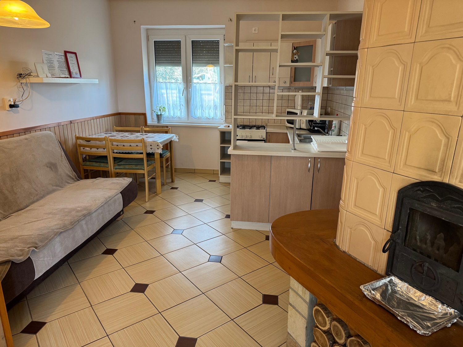 A nappali a cserépkályhával és a kanapéval